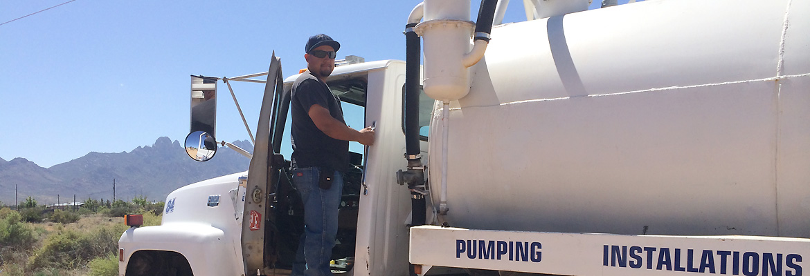 a septic tank truck hitched to a trailer with a digger on top